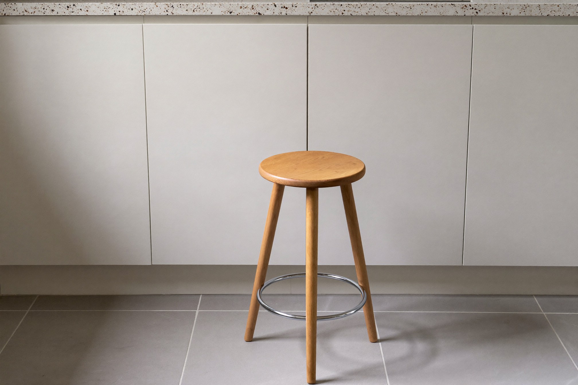 Prawidłowy hoker z siedziskiem counter-height wciśnięty pod blat kuchenny 90 cm — widok z boku przy oknie