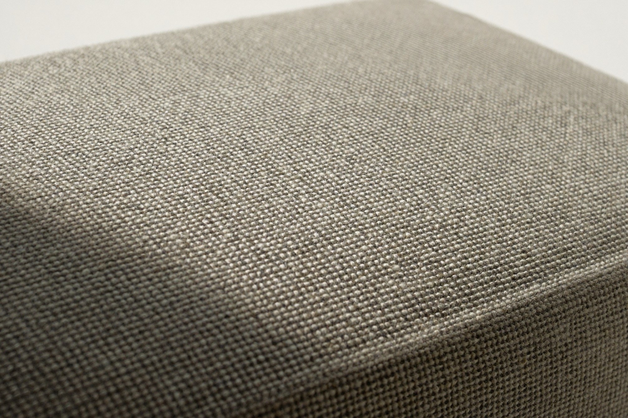 Ekstremalne zbliżenie na splot tkaniny obiciowej: nitki osnowy i wątku widoczne w bocznym świetle