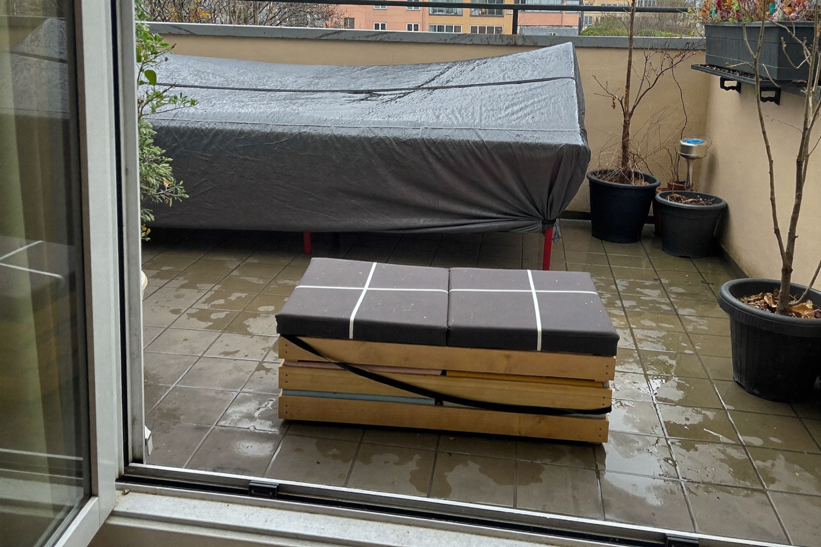 Balkon późną jesienią: poduchy złożone w skrzyni, meble przykryte oddychającym pokrowcem